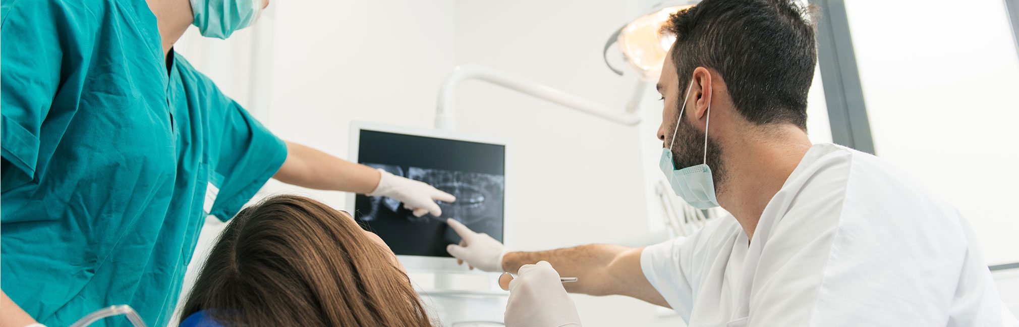 Male dentist looking at dental x rays with a dental hygienist | Robson Family Dentistry in Bellefontaine, OH